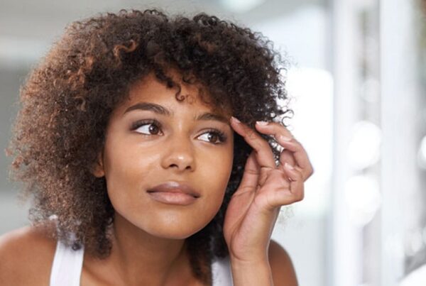 woman looking in the mirror after her eyelid surgery in New Jersey