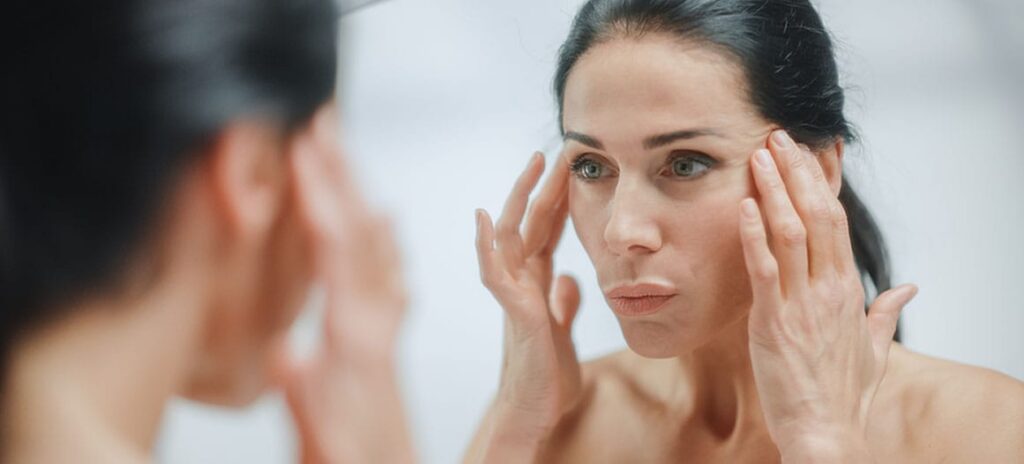 woman looking in the mirror after her facelift in New Jersey